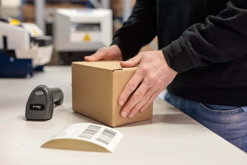 Ein Versandkarton wird am LCR-Packplatz vorbereitet