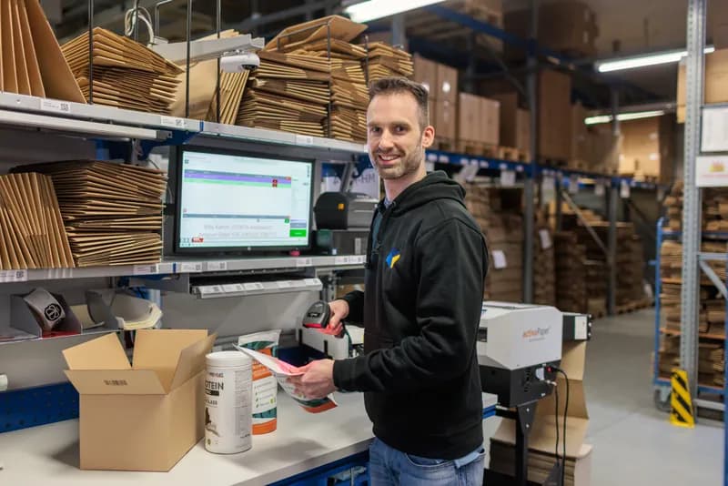 LCR Mitarbeiter verpackt eine Bestellung am Versandtisch